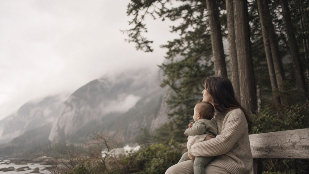 A parent and infant looking out over the mountains near Squamish