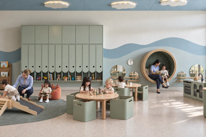 Infant and toddler classroom at Kinder Roots Redbridge with a reading nook, climbing frame and play kitchen